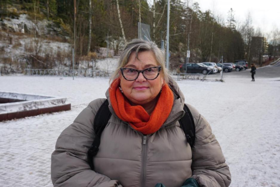 Kvinne i 60&aring;rene st&aring;r godt kledd ute p&aring; vinteren. Sn&oslash;en ligger p&aring; bakken rundt henne