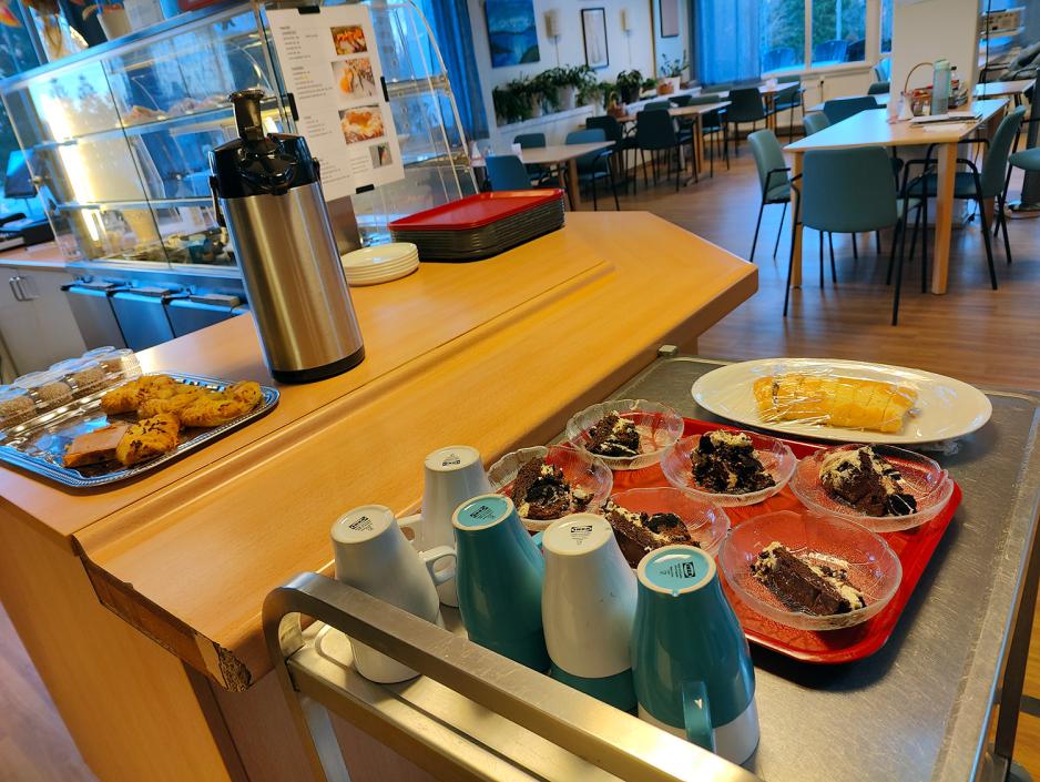Bord med rullekake, kaffekopper i kaf&eacute;lokale