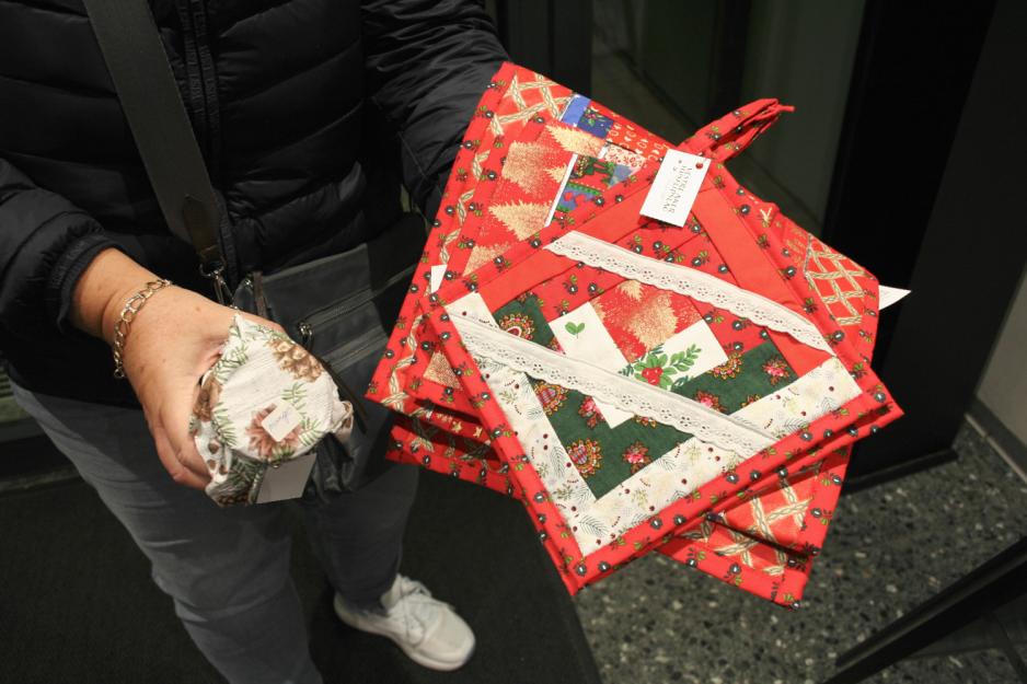 Kunde viser frem hjemmelagde grytekluter, syltet&oslash;y og l&oslash;pere fra Vestre Aker Husflidslags julemarked