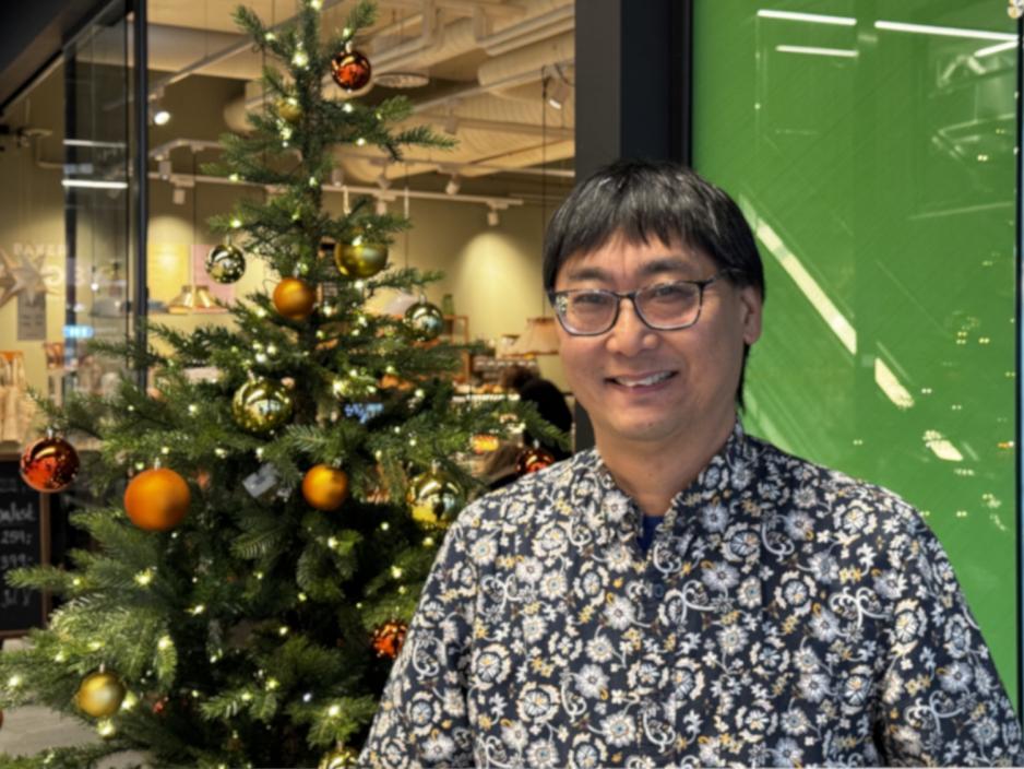 Mann st&aring;r foran juletre