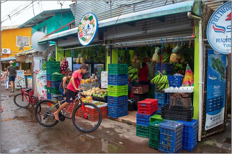 En gutt p&aring; sykkel titter p&aring; bananer til salgs i Costa Rica 