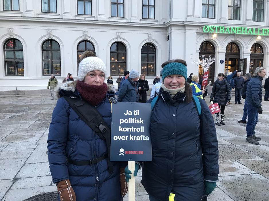 To demonstranter holder skilt utenfor &Oslash;stbanehallen.