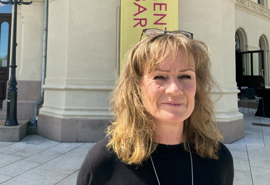 Kvinne med svart genser og solbriller p&aring; hodet. Foran Nobels fredssenter.