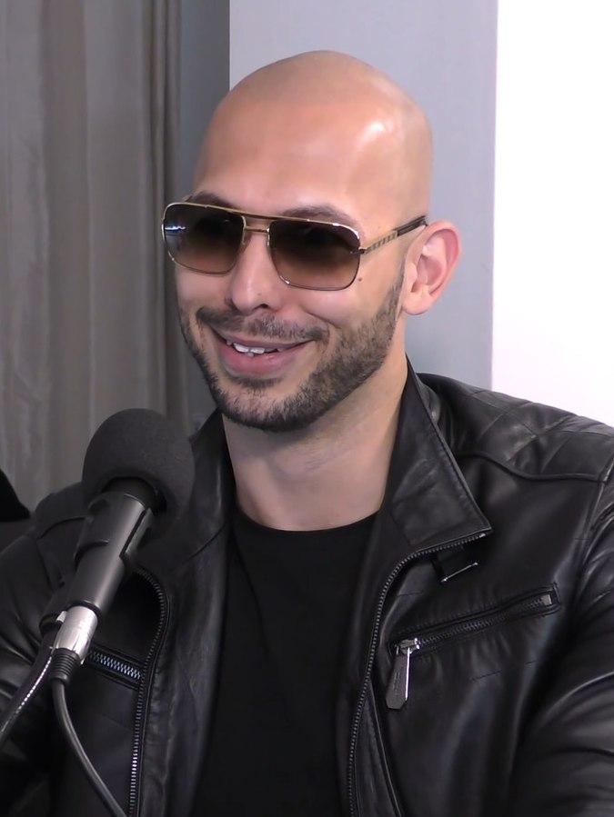 Andrew Tate som smiler, med solbriller p&aring; hodet, underbitt og mellomrom mellom tennene