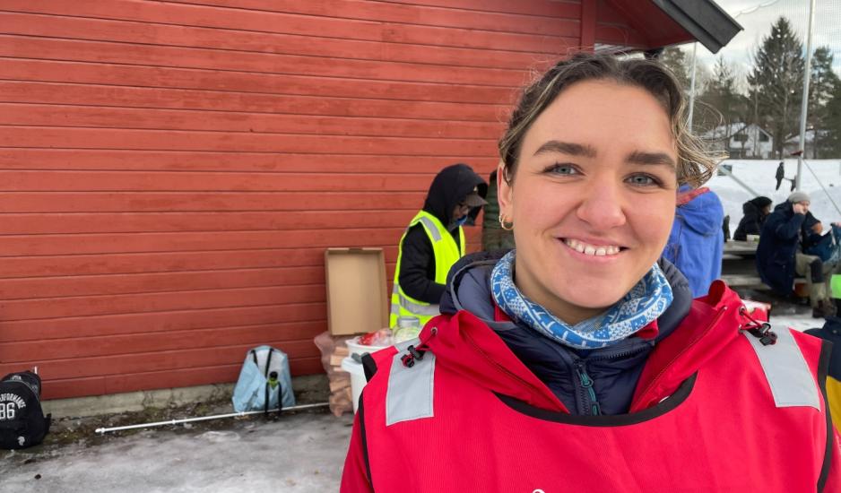 Andrine Farnes Hilton st&aring;r foran et r&oslash;dt bygg.
