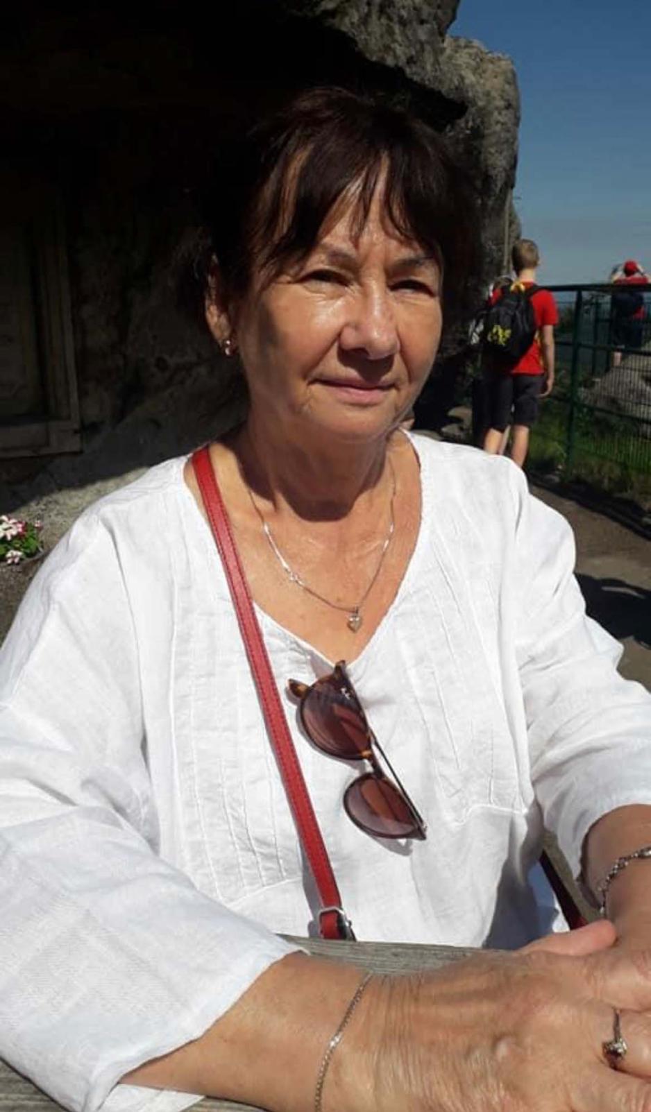 en smilende dame med kort brunt h&aring;r og hvit skjorte