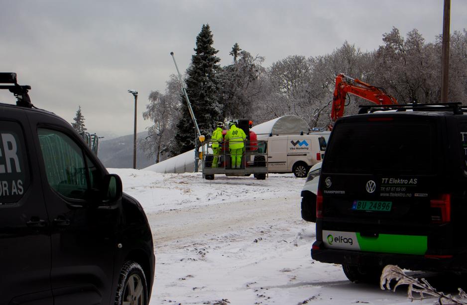 To bygningsarbeidere st&aring;r i en kran. Kranen befinner seg &oslash;verst i en slal&aring;ml&oslash;ype ved Tryvannst&aring;rnet.