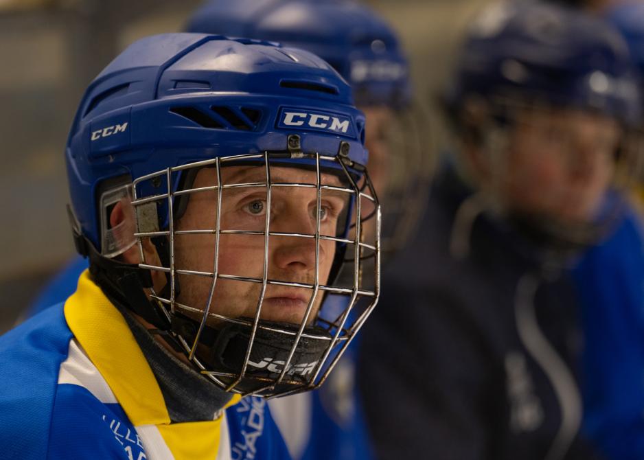 Bandyspiller Ola Gundersen Sk&aring;re med hjelm p&aring; benk