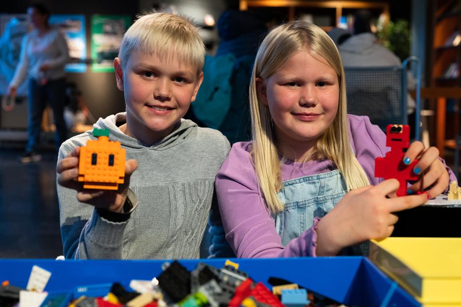 to lysh&aring;rede barn holder opp hver sin legofigur. 