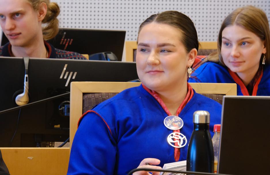 Elle Nystad smiler i rettssaken. I bakgrunnen smiler ogs&aring; en annen. 