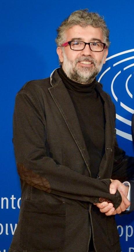 Erol Onderoglu framfor bl&aring; vegg. 