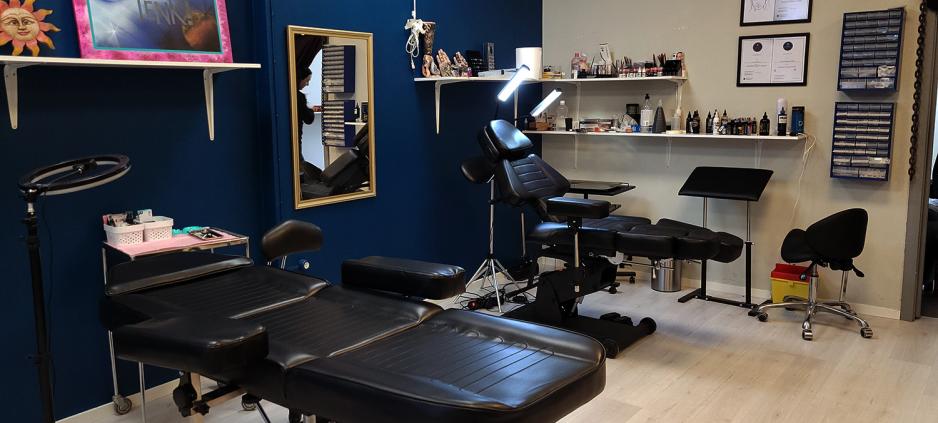 Eit tatoveringsstudio med to tatoveringsstolar og bl&aring; vegg i bakgrunnen. 