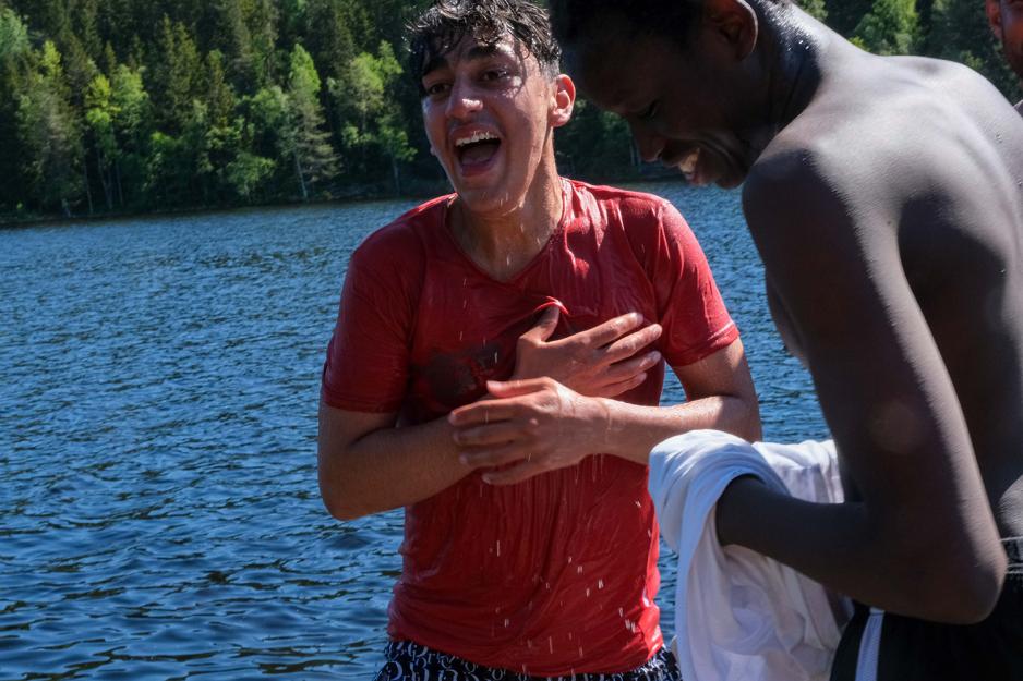 En gutt holder seg til hjertet og er helt v&aring;t etter &aring; ha badet i sj&oslash;en.