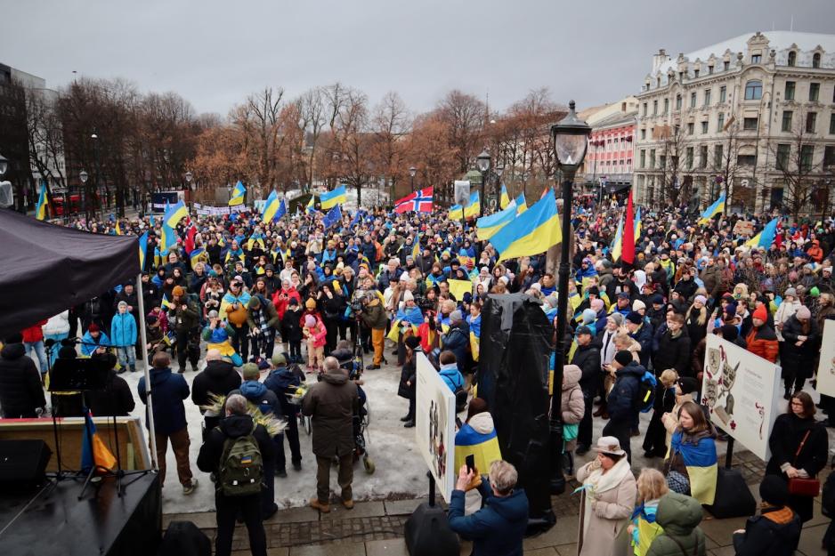mange mennesker som st&aring;r p&aring; Eidsvolls Plass med ukrainske flagg