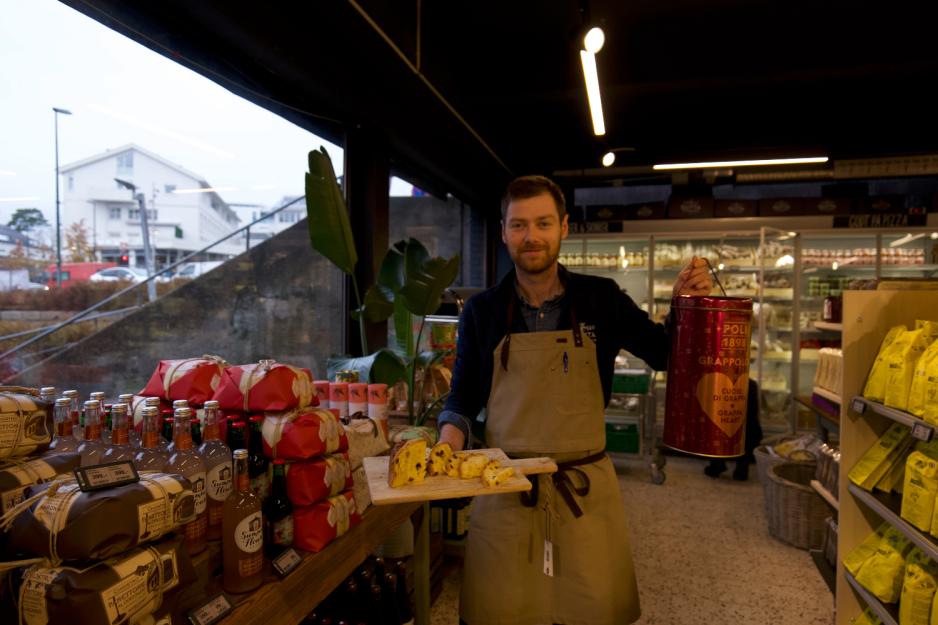 Mann som holder julebr&oslash;d og tinnboks.