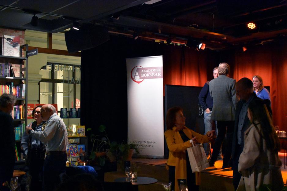Mennesker som diskuterer p&aring; en kaf&eacute;