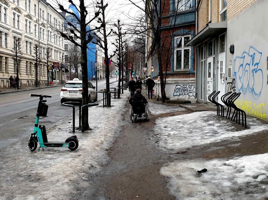 H&aring;kon Bjar beveger seg nedover gata i rullestol. Gatekanten er dekket av is og sn&oslash;.