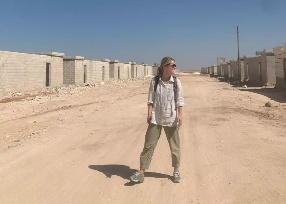 En kvinne avbildet p&aring; avstand i &oslash;rkenlandskap i Syria.