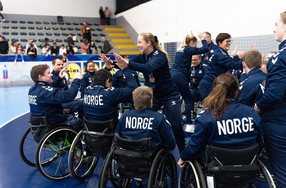 Spillere og trenere tar high five og gratulerer hverandre utp&aring; banen etter bronsefinalen
