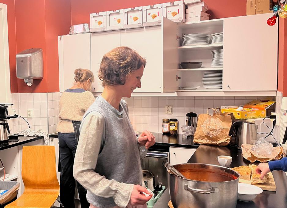 To damer st&aring;r i en kiosk. De deler ut mat. 
