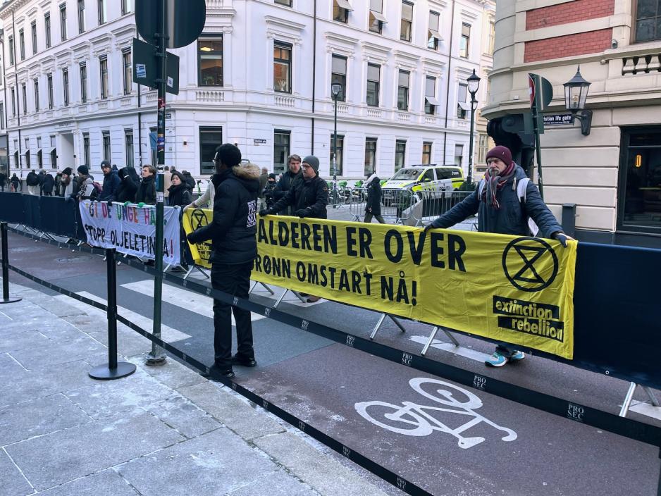 En gruppe demonstranter holder et banner utenfor Equinor-konferansen.