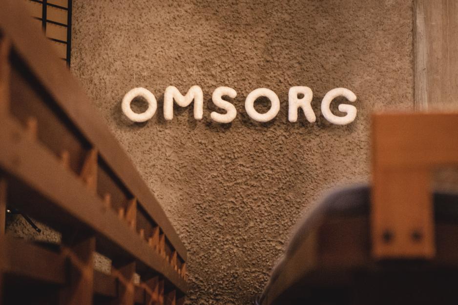 Ordet Omsorg st&aring;r skrevet i gips-materiale og henger p&aring; veggen i Sinsen kirke.