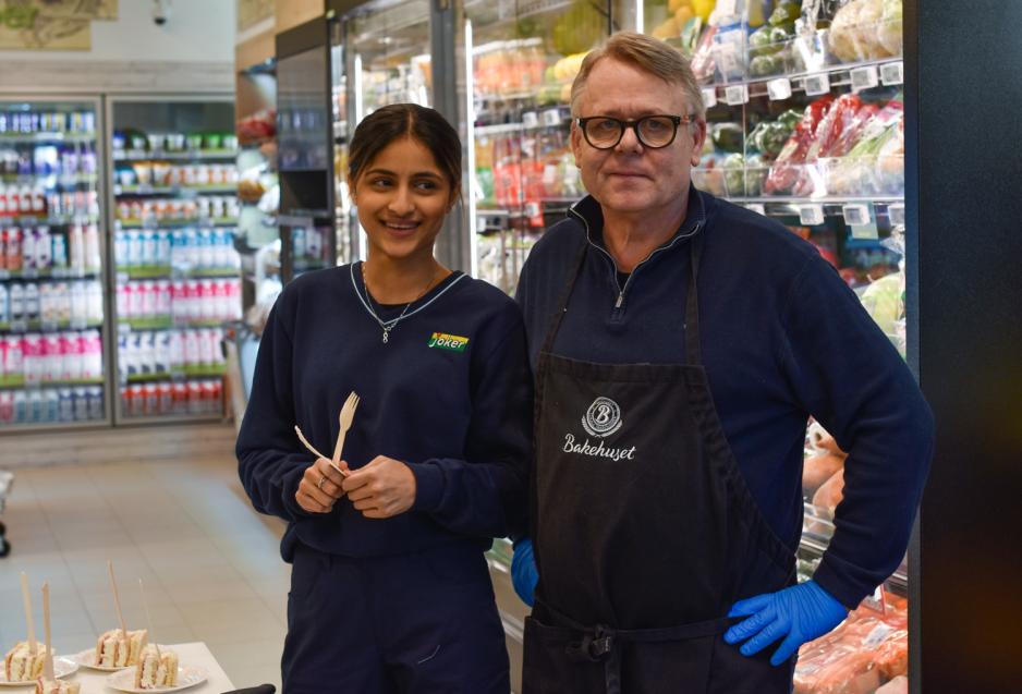 Joker-ansatt og leverand&oslash;r fra bakerhuset deler ut kake. 