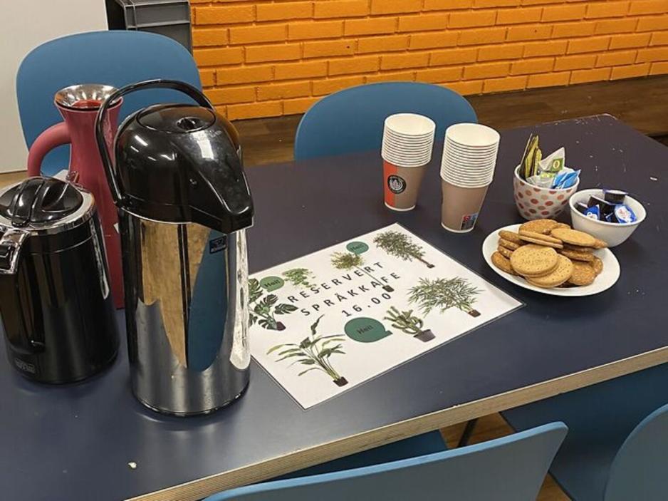 Kaffe, te og kjeks st&aring;ende p&aring; et bord