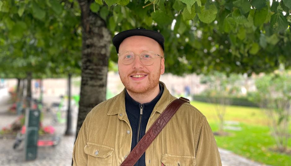 Et foto av smilende Lars G&oslash;ran Hansen under et tre p&aring; Karl Johans gate i Oslo. 