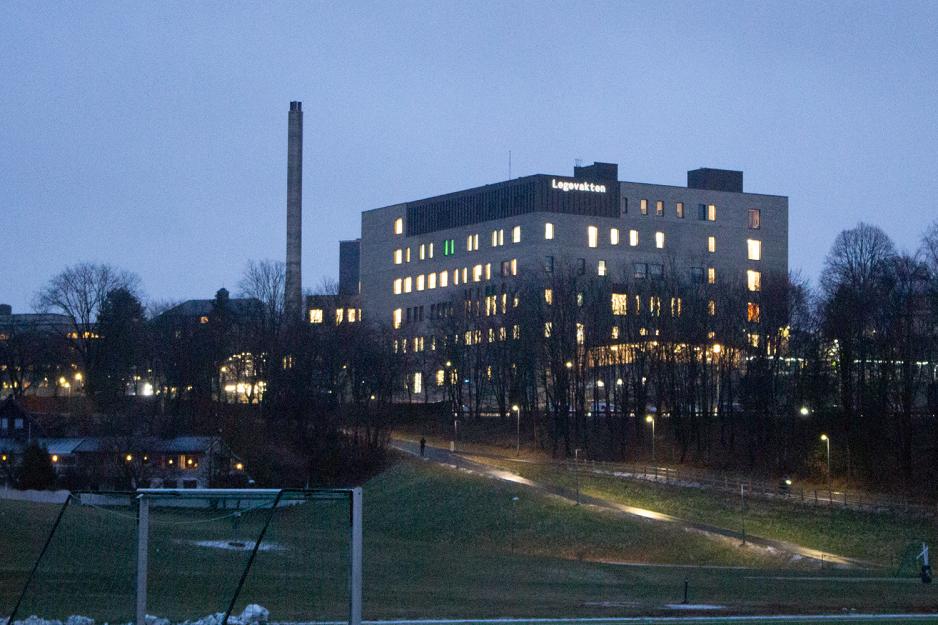 Bygget sett fra trikkestoppet, med lysende bokstaver der det st&aring;r &laquo;Legevakten&raquo;. Med i bildets forgrunn er en fotballbanet, og bygget ligger p&aring; en h&oslash;yde. Det er m&oslash;rkt ute. 