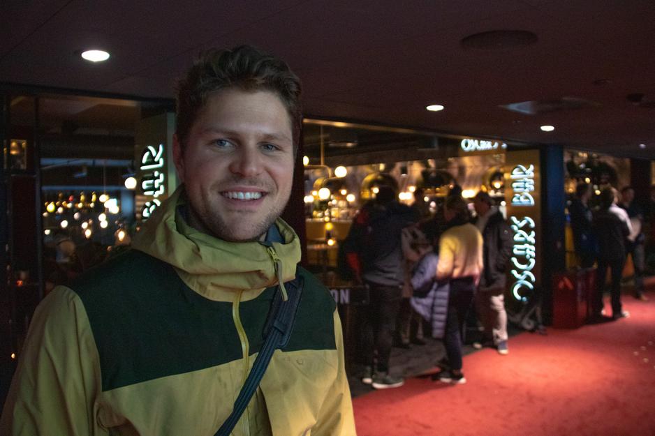 Mann med kr&oslash;llete h&aring;r og gul jakke