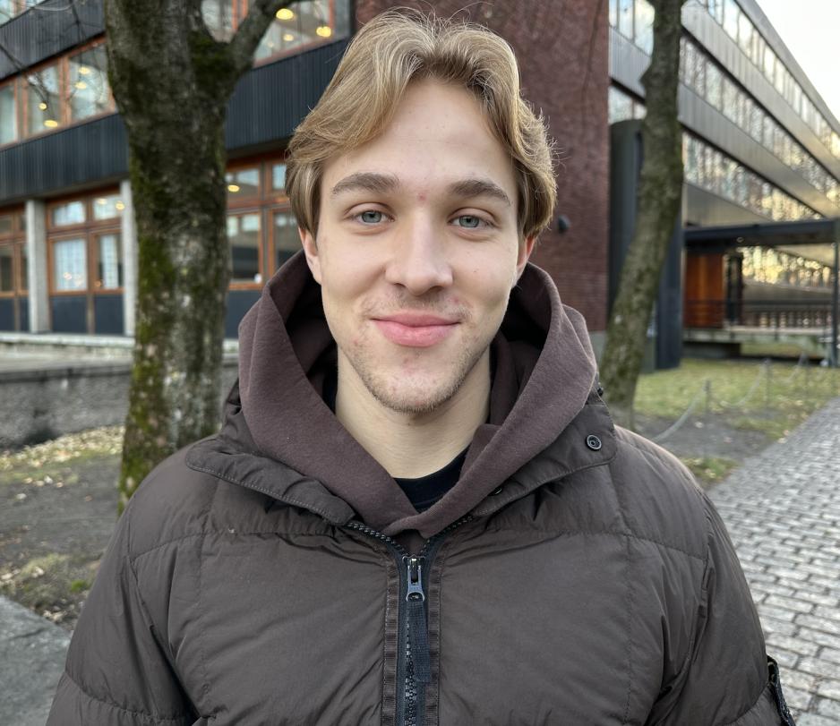 En gutt med m&oslash;rke blondt h&aring;r smiler mot kamera