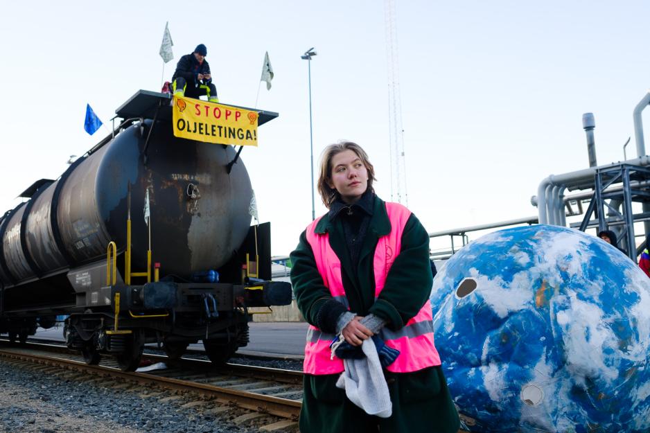 Emilie R&oslash;ine &Oslash;steb&oslash; st&aring;r foran en blokkert tankvogn spent opp med banner fra Extinction Rebellion.