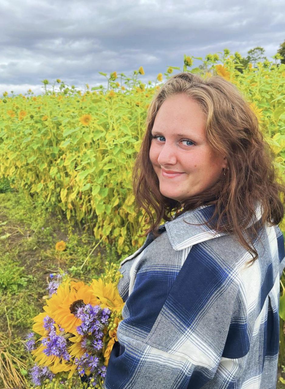Ronja Vestlund Bysveen st&aring;r i en blomstereng.