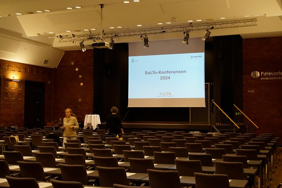 Konferanserom med masse stoler og et lerret hvor det st&aring;r Salto