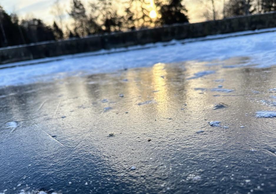 En m&oslash;rk is p&aring; Vesletjern med svak sol i bakgrunnen. 