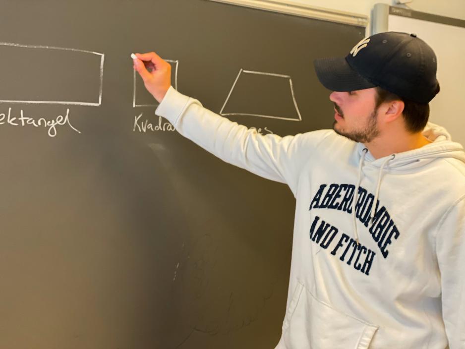 Steffen som vikar skriver p&aring; tavla for elevene som er i klasserommet