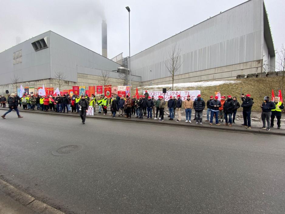 mennesker st&aring;r p&aring; en lang rekke p&aring; andre siden av veien