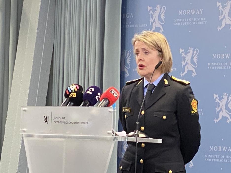 Sjef i politiet, Benedicte Bj&oslash;rnland st&aring;r if&oslash;rt bl&aring; genser og ser utover pressekonferansen. 