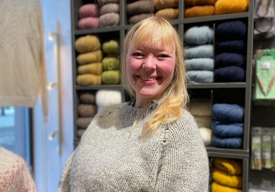 Bildet viser Tina Hauglund, ansatt i garnbutikken Fru Kvist Gr&uuml;nerl&oslash;kka. Bildet er tatt inne i butikken med garnn&oslash;ster i bakgurnnen. 