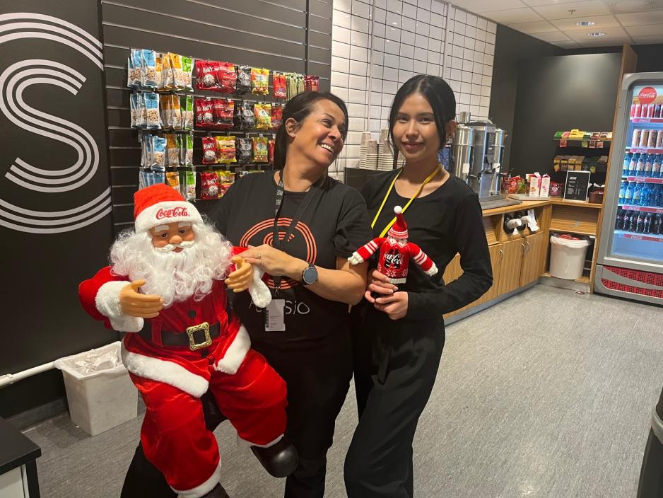 Ziva Engel og Siriporn Siriwal viser fram julenissen de har f&aring;tt i gave av Coca Cola. 