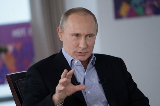 Russlands president Vladimir Putin if&oslash;rt dress, gestikulerer idet han snakker i det som ser ut som et m&oslash;terom med vinduer i bakgrunnen.