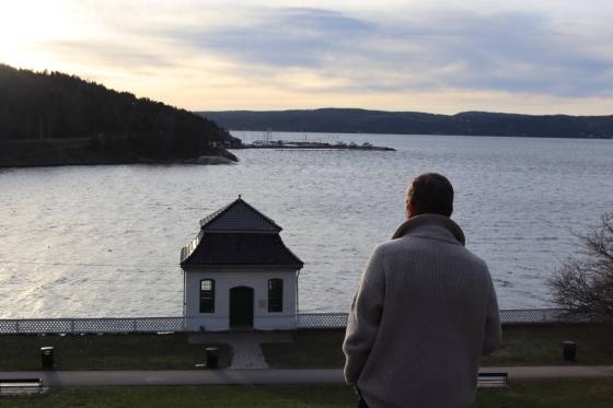 Arild Berg st&aring;r p&aring; toppen av en bakke, nedenfor er det et hus.