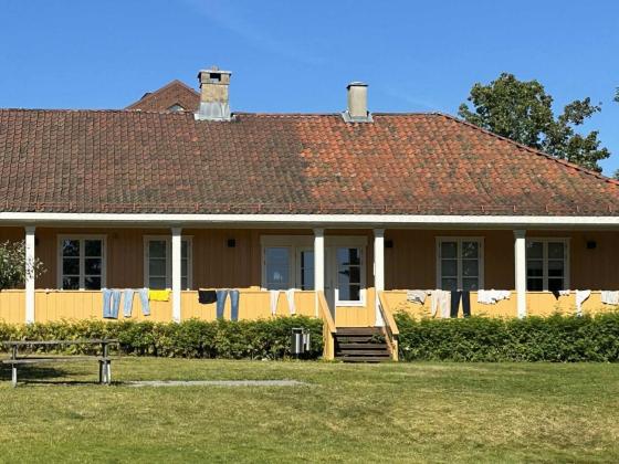 Et gult hus hvor de har hengt kl&aelig;r p&aring; gelenderet
