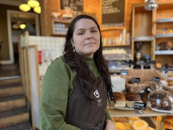 Bilde av assisterende leder Inga Staugaite p&aring; &Aring;pent Bakeri, foran disken i bakeriet.
