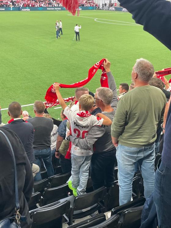 Far og s&oslash;nn som holder rundt hverandre p&aring; fotballkamp
