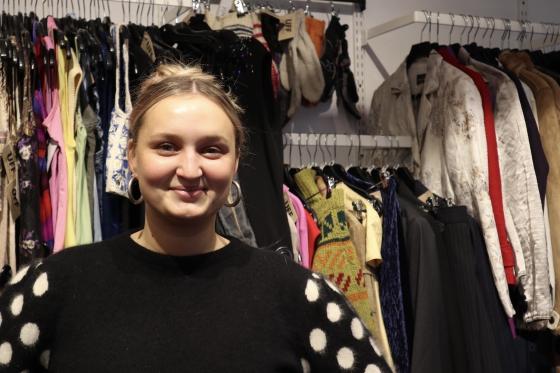Sunniva som st&aring;r i bruktbutikken UFF, der hun jobber.