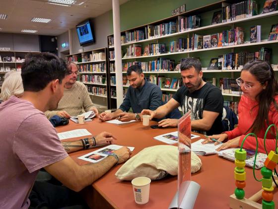 Mennesker rundt et bord p&aring; et bibliotek