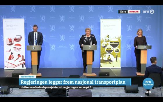 Erna Solberg, Guri Melbye, og Knut Arild Hareide st&aring;r ved siden av hverandre p&aring; et podium, og legger frem den nasjonale transportplanen for 2022-2033.