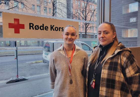 Seniorkonsulenter i Barnas R&oslash;de Kors, Martine Jakobsen og Marielle Halvorsen, avbildet i R&oslash;de Kors' lokaler i Hausmannsgate 23, foran et R&oslash;de Kors-skilt.